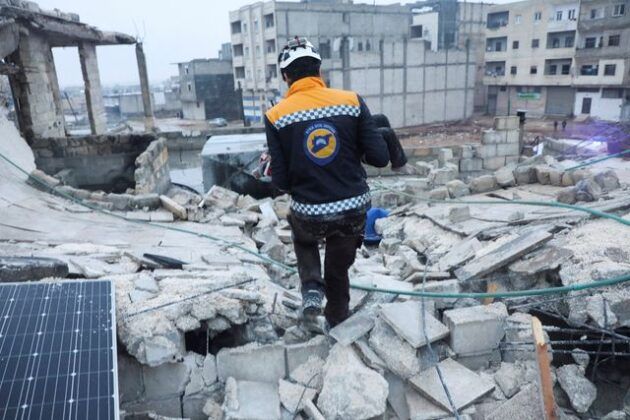 Ein Rettungshelfer trägt ein Kind nach einem Erdbeben in einem beschädigten Gebäude in Azaz